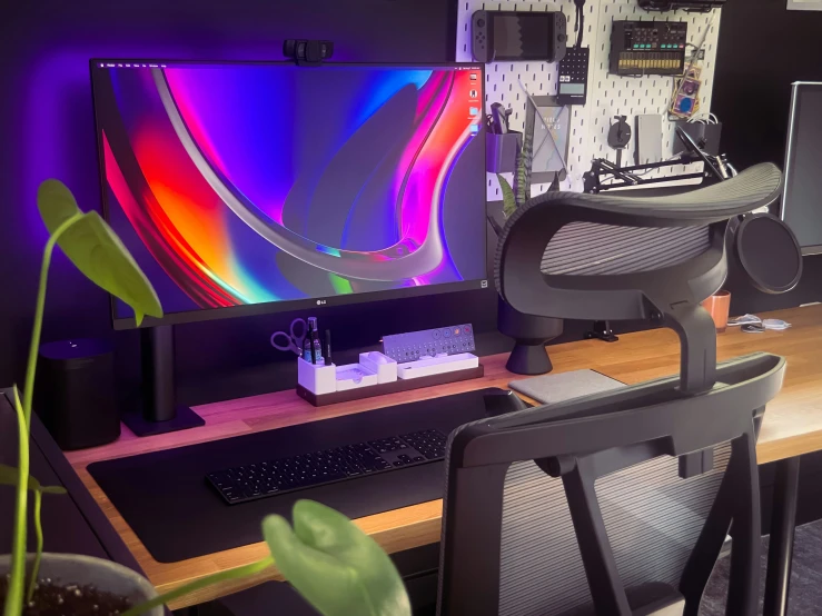 an office with a colorful screen and a large computer