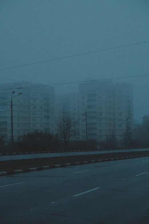 dark grey buildings and electrical wires by the highway