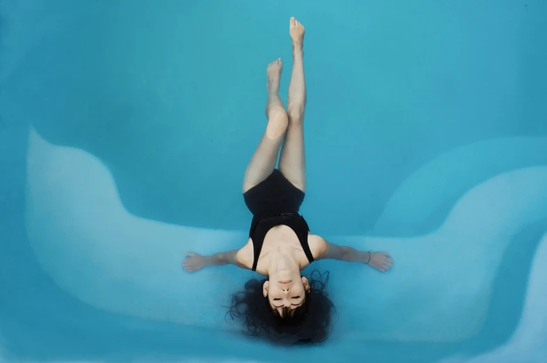 a woman is diving into an empty pool