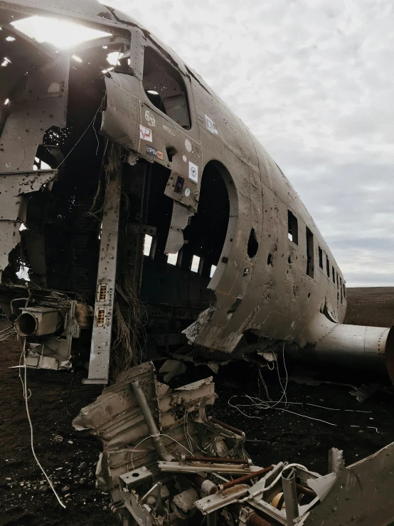 the underside of an old airplane on a dirt ground