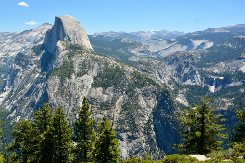 mountains covered in tall and green trees with a sky background