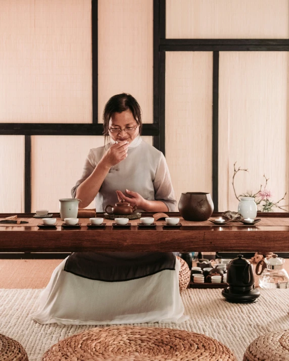 a woman wearing a white shirt using a long wood table