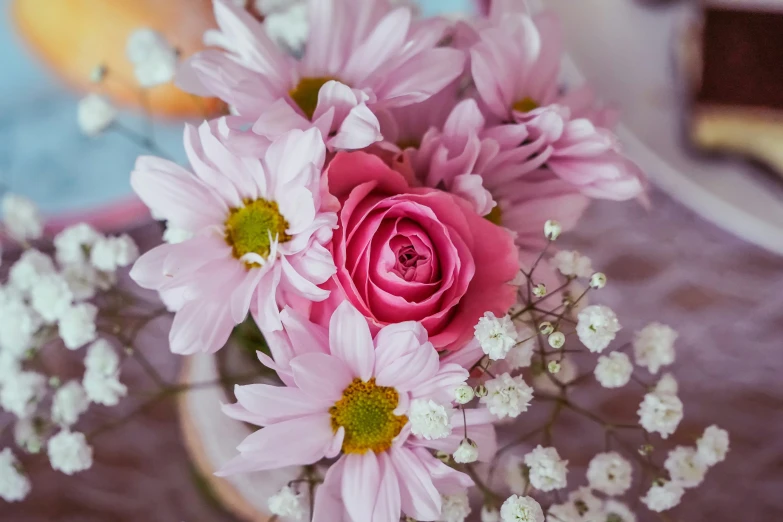 some pink flowers sitting in a bowl on a table