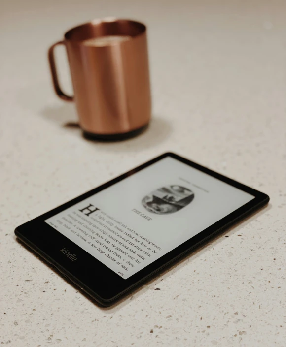 a book about sex is on the tablet and beside a cup of coffee