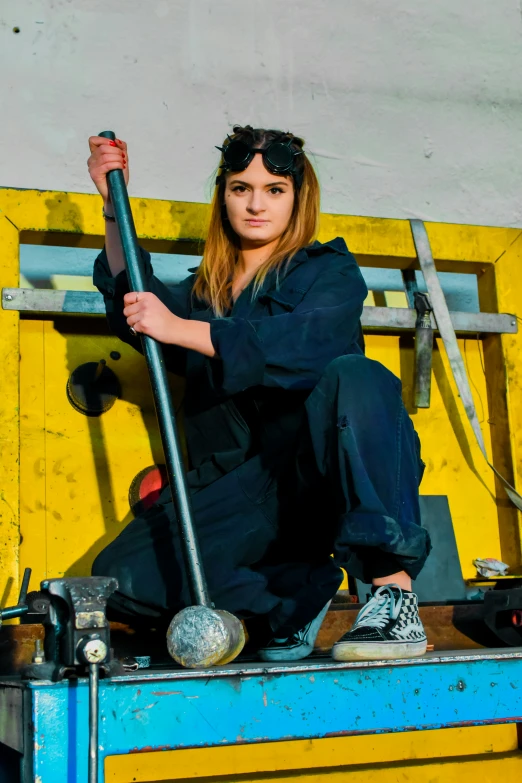 a woman in black sitting on top of a yellow and blue crate