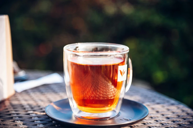 a cup filled with tea sits on a plate