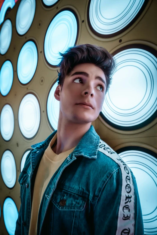 a young man is standing in front of a clock