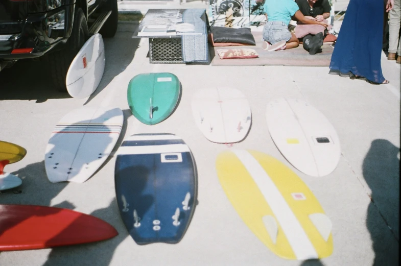 many surfboards on the sand near an ocean