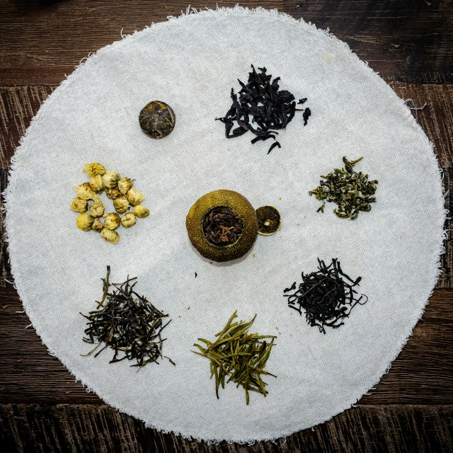 a white cloth covered with many different different kinds of teas
