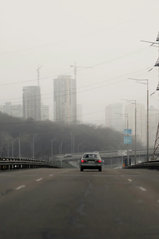 a car drives across an over pass in the fog