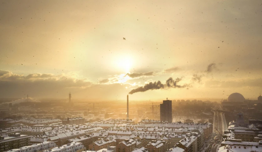 view over a city on a hazy day with steam rising from stacks of smoke