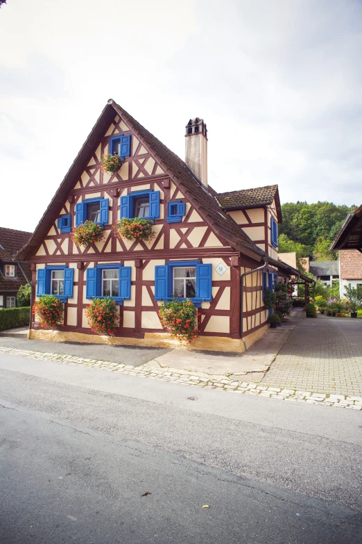 a building with some flowers on it next to a road