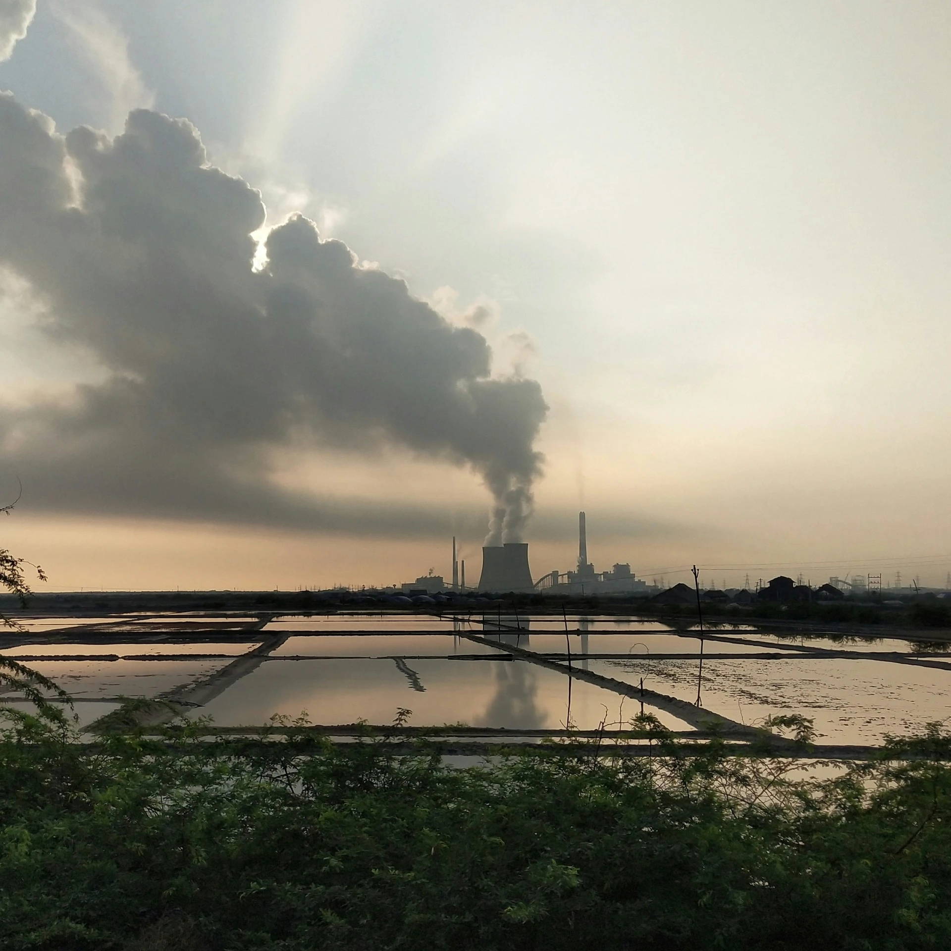 the smokestack of a factory emits from its chimney