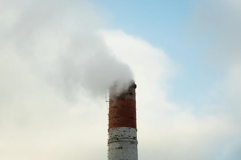 smoke pouring out of a pipe into the sky