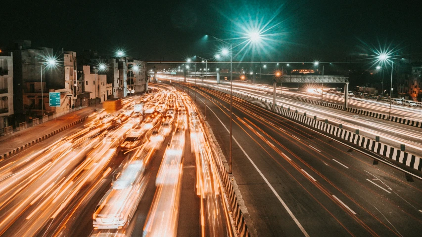 several cars are driving down a city street at night