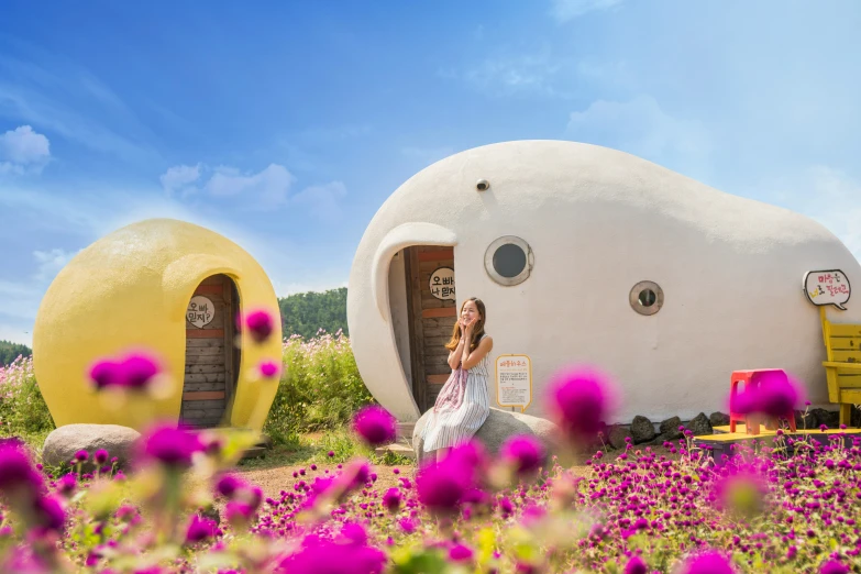 a woman kneeling in the doorway to a house made out of two spherical objects