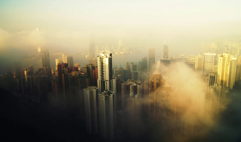 a city skyline with tall buildings and fog over them