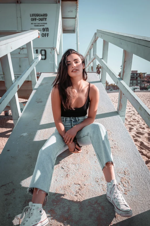 a woman sits on a bench wearing sneakers