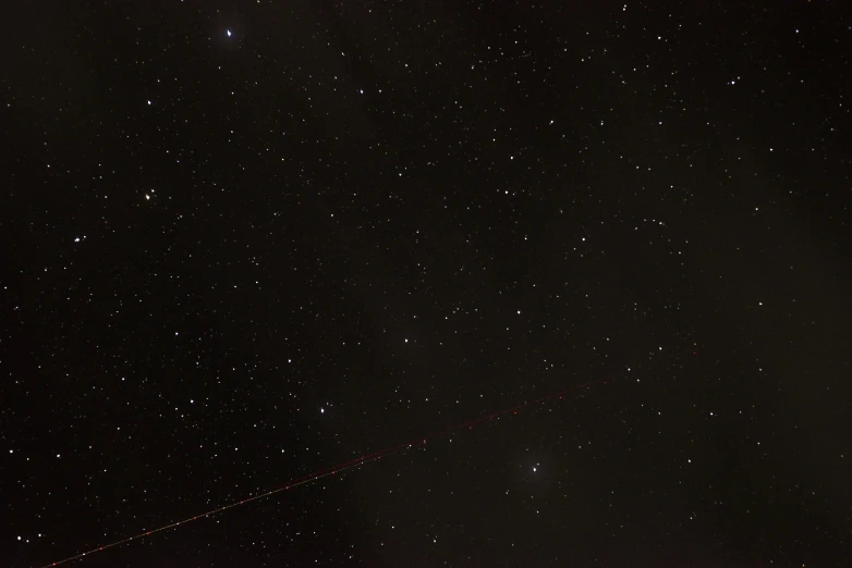 a black night sky has a star trails across the background