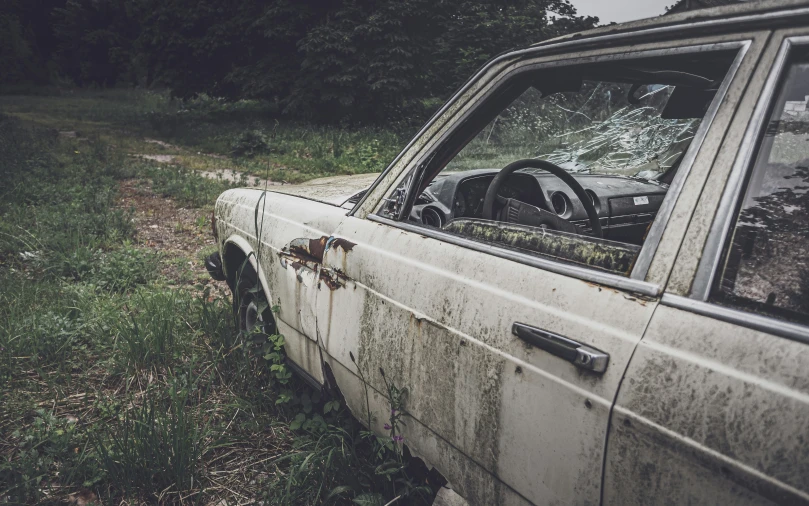 an old car sitting in the grass