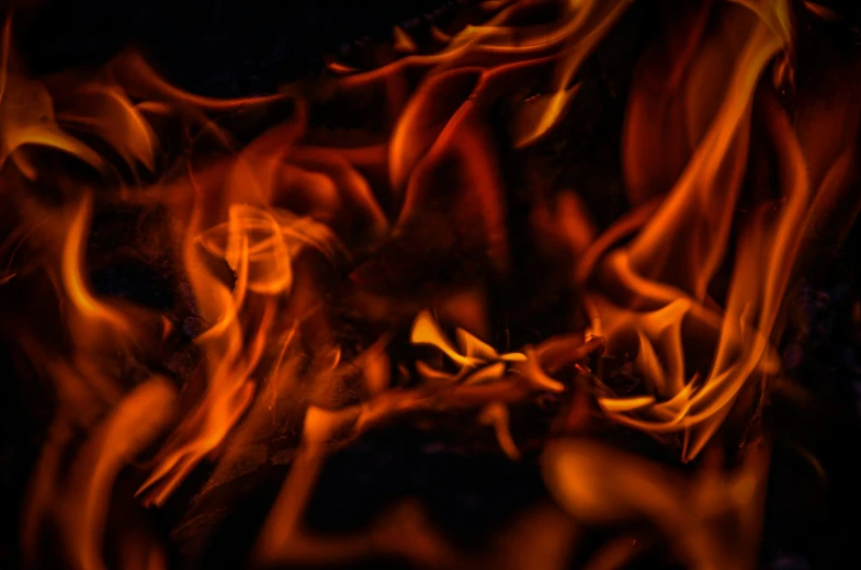 many different colored flames on a dark background