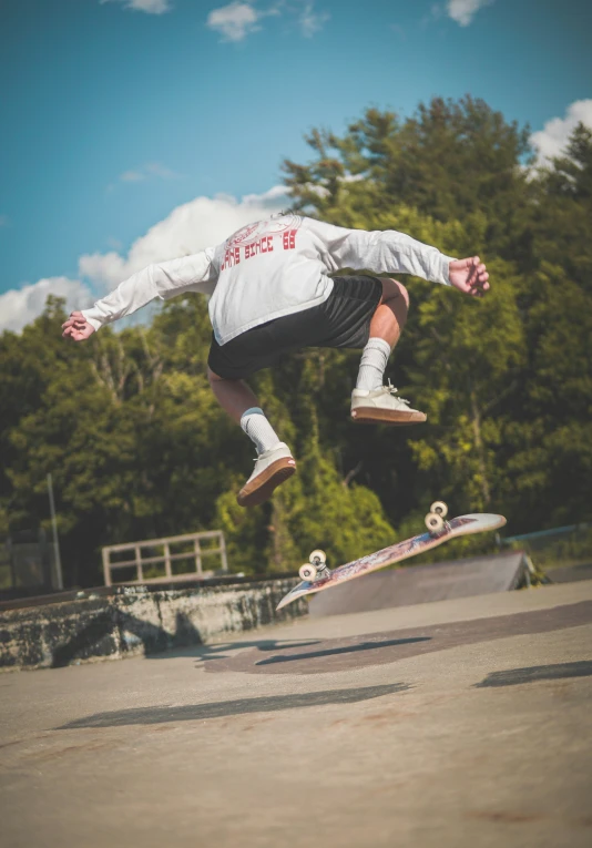 a man in white shirt doing a trick on skateboard