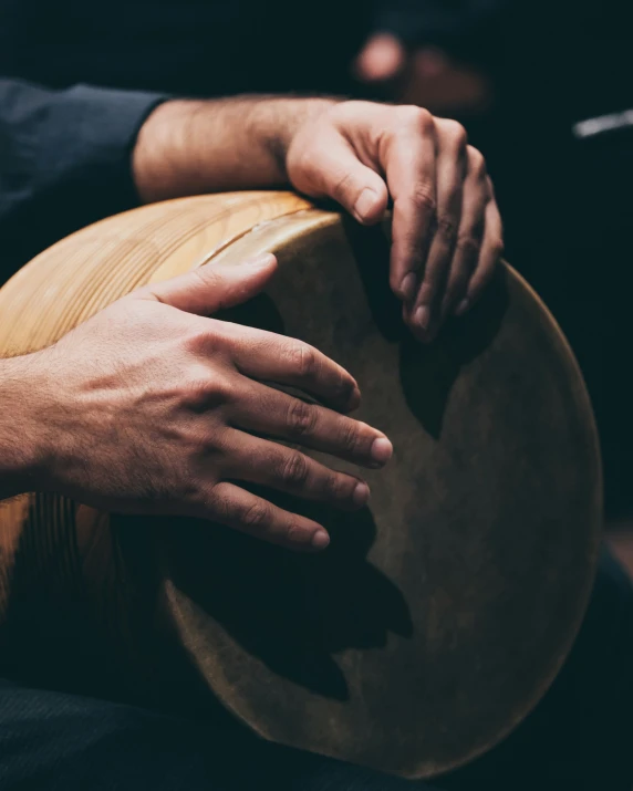 two hands touching the drums on a black background