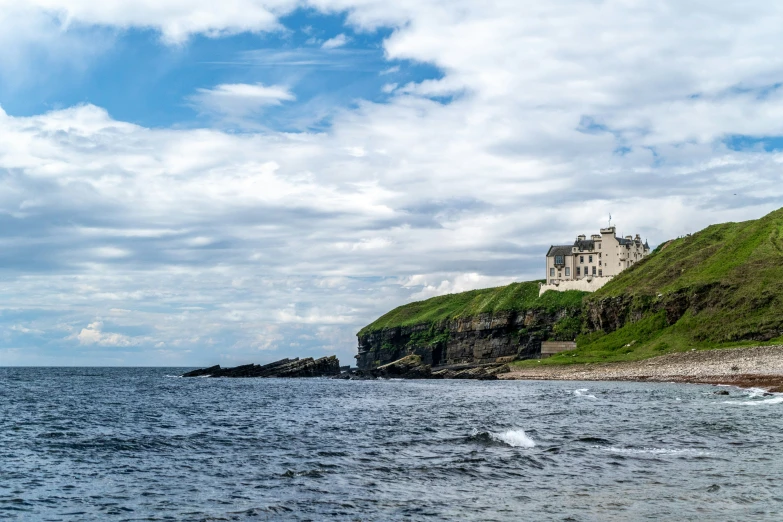 a castle perched on top of a hill near the ocean