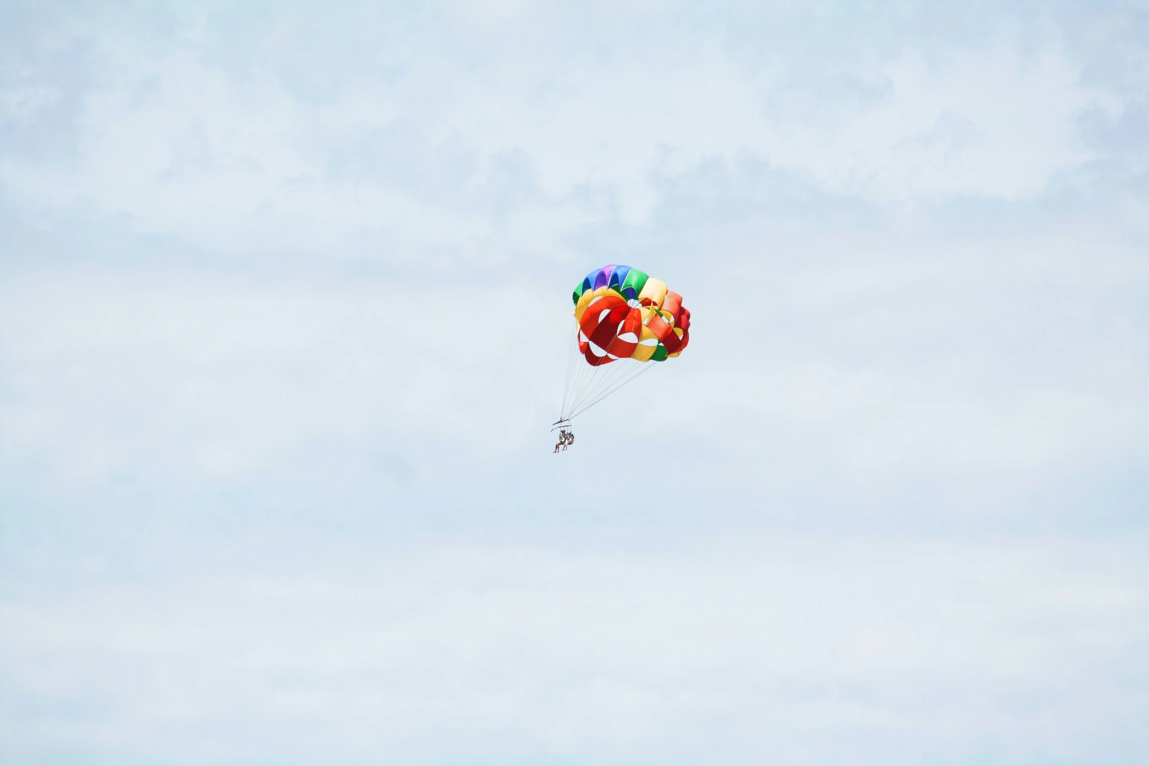 people are floating in the air with colorful kites