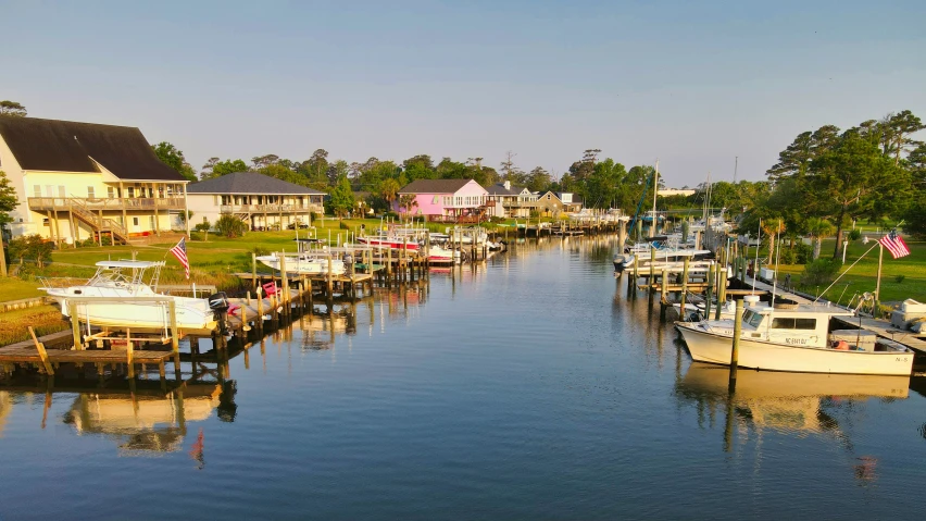 many boats are parked on a river near houses