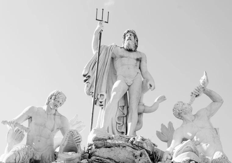 a statue of jesus stands on top of some other statues