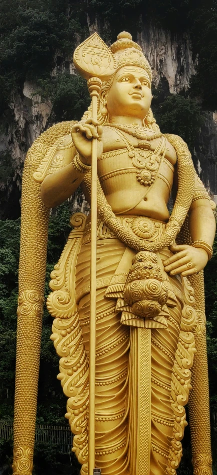 the large statue is gold with designs on it