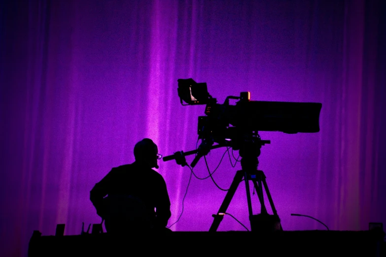a man is setting up his camera and his dark purple backdrop