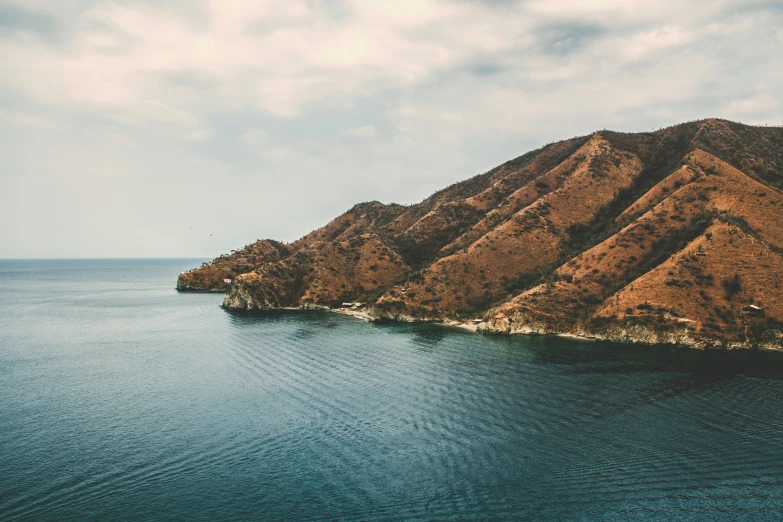 some mountains by the ocean that look like they are in the middle of nowhere