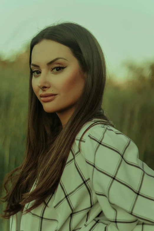 woman standing in a field of grass wearing a white and black jacket