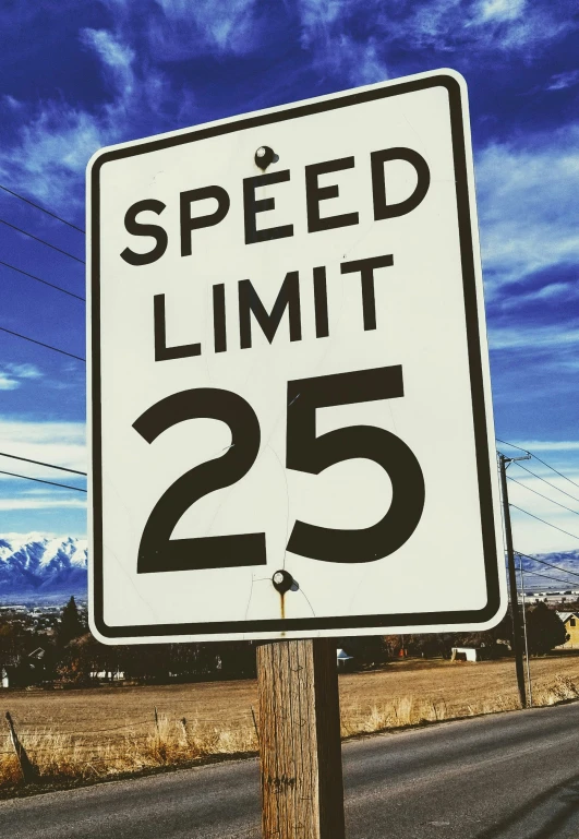 a speed limit sign with a sky background
