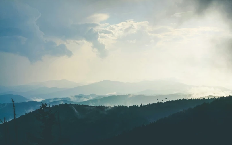 a view of the sky and hills with trees