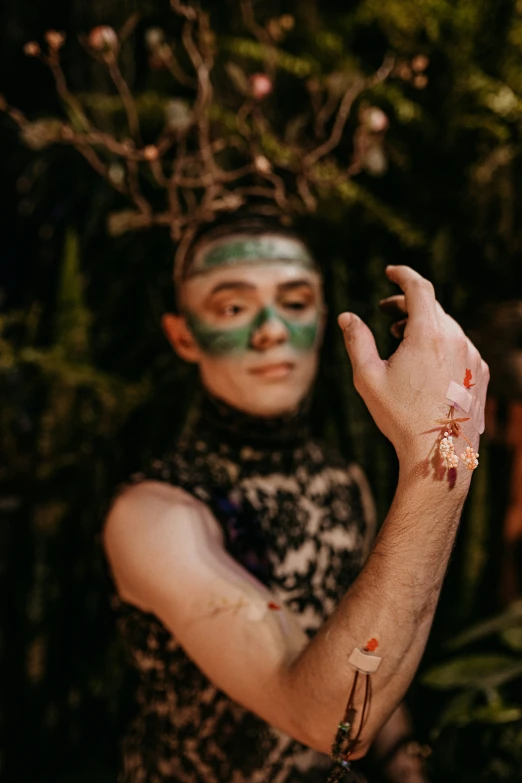 a person with painted hands holds their fingers up to the camera