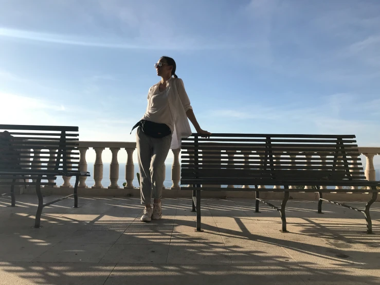 a person standing on a bench with her back against a railing