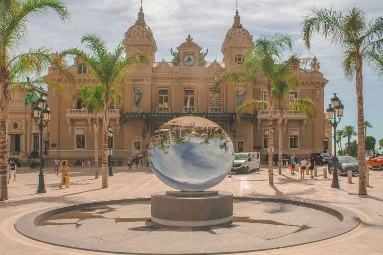 a large building surrounded by palm trees and a metal sculpture