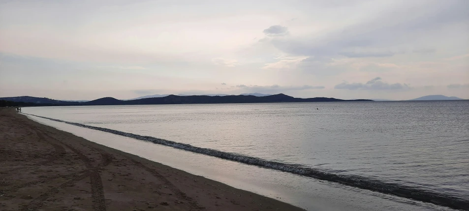 a beach near the water with the shoreline in the foreground