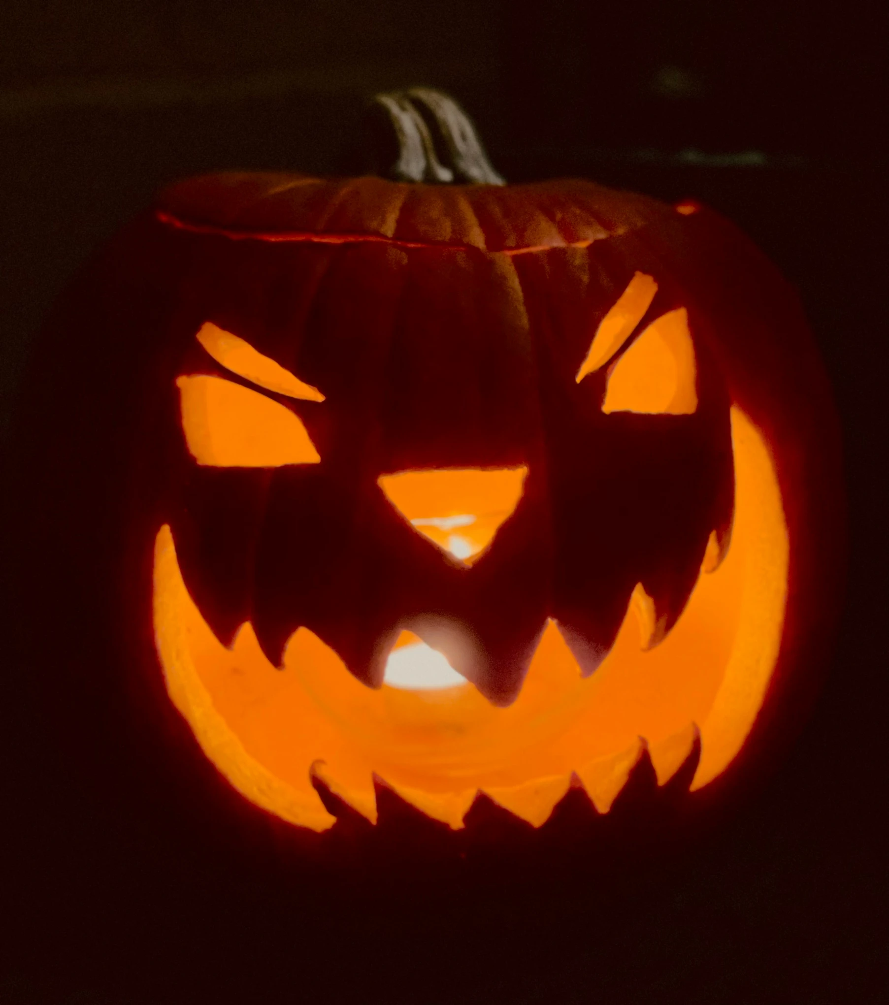 a halloween pumpkin with carved faces is lit up