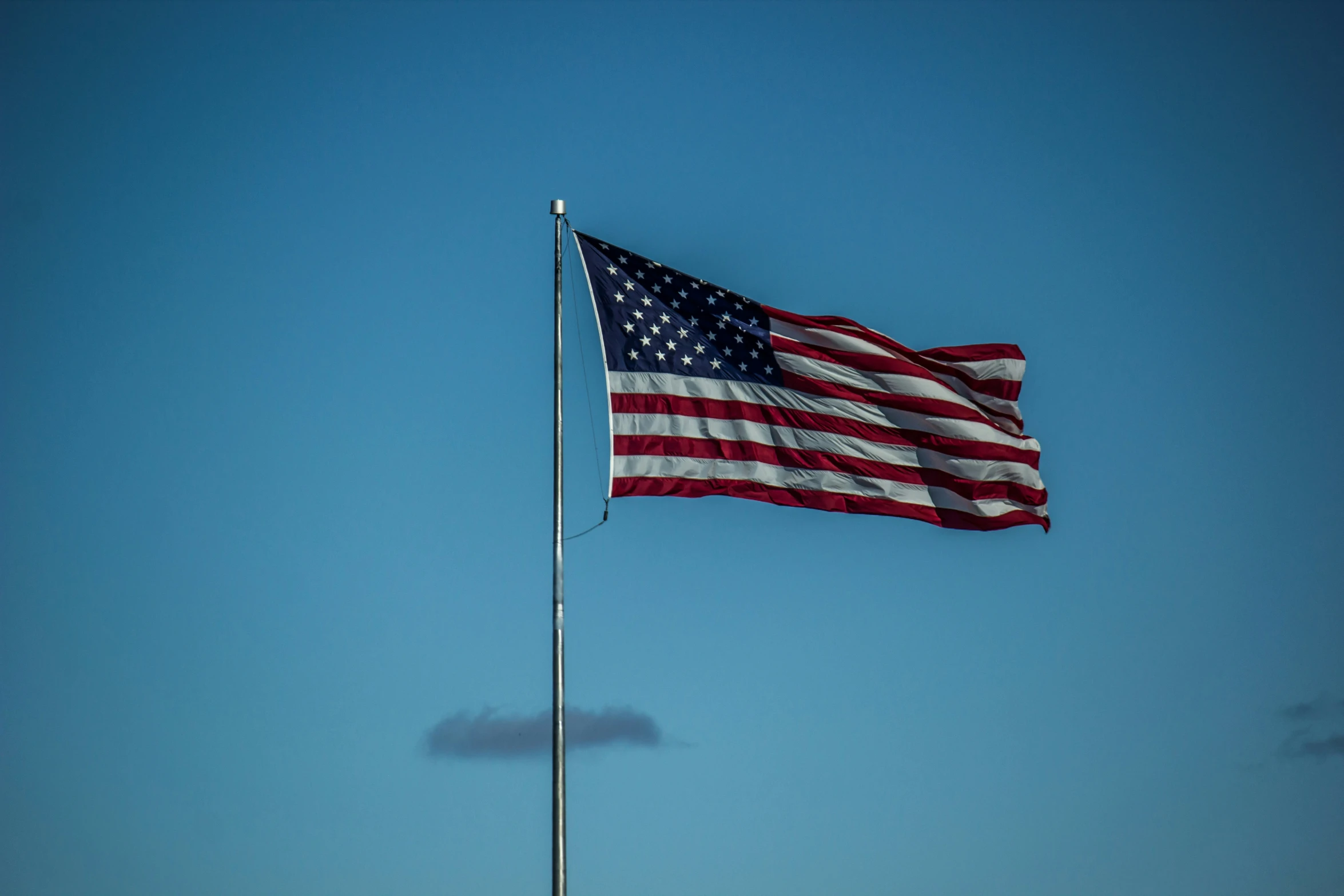 an american flag flying on the side of a blue building