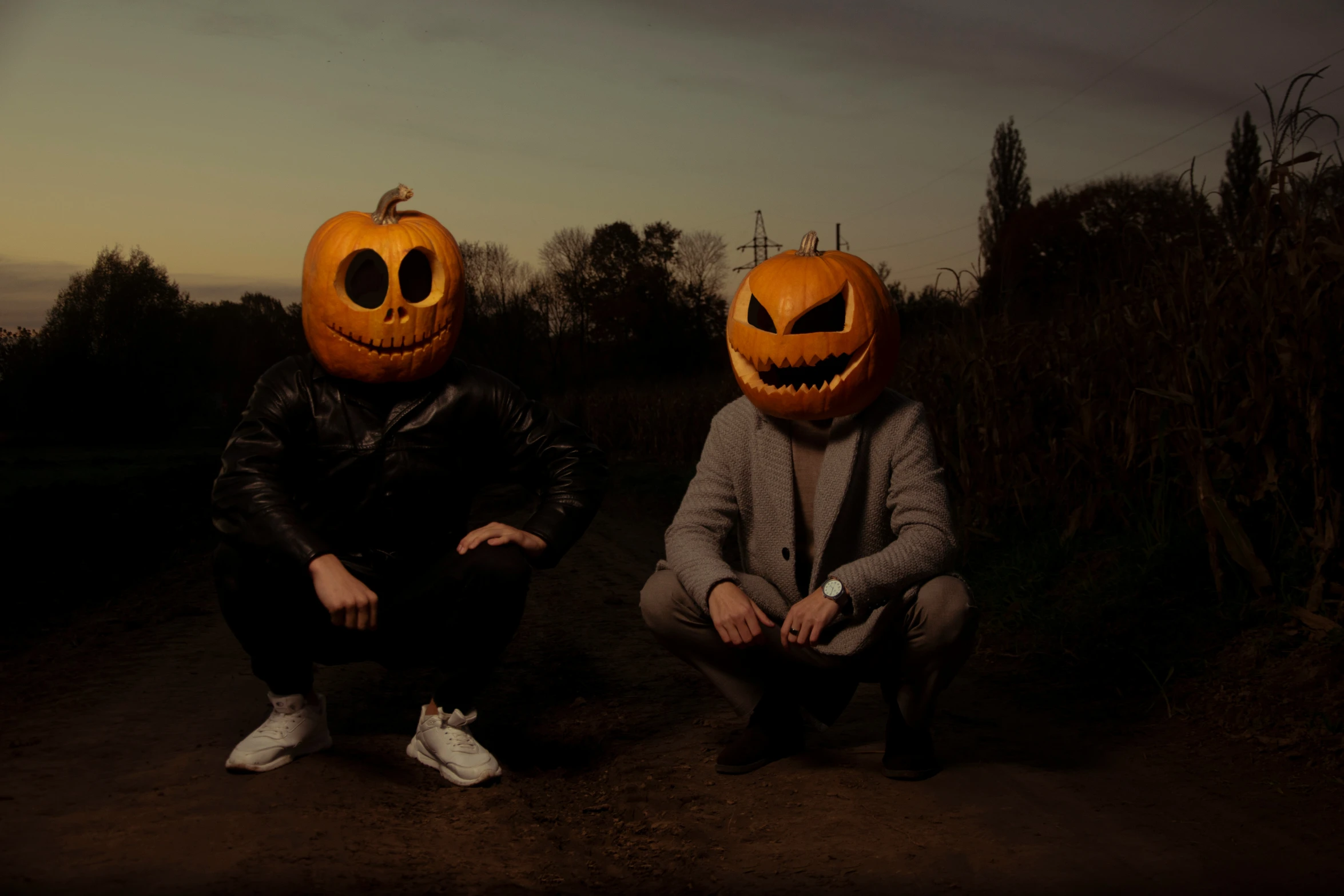 two people wearing pumpkin faces sitting next to each other