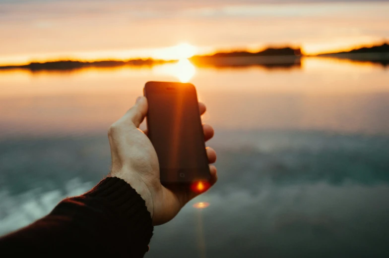 a person is holding up their phone in front of the camera