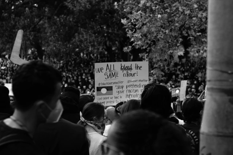 a group of people with signs and a phone in front