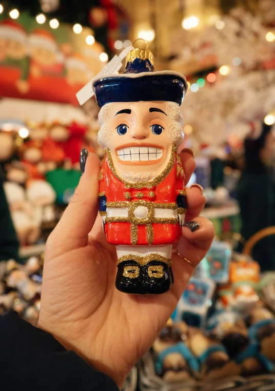 someone holding a christmas figurine in their hand