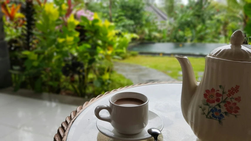 a tea pot on a table and a cup on the table