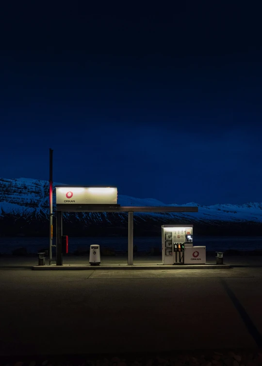 a gas station with snow on the hill behind it