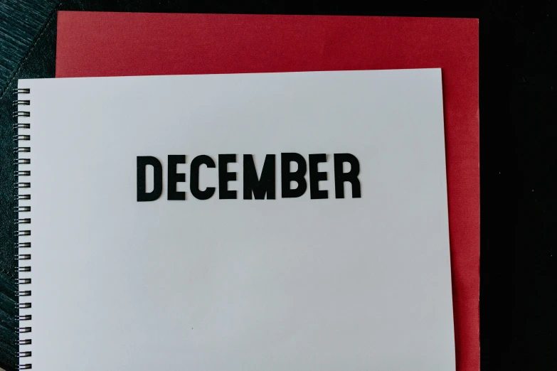 a white notebook with the word december on it